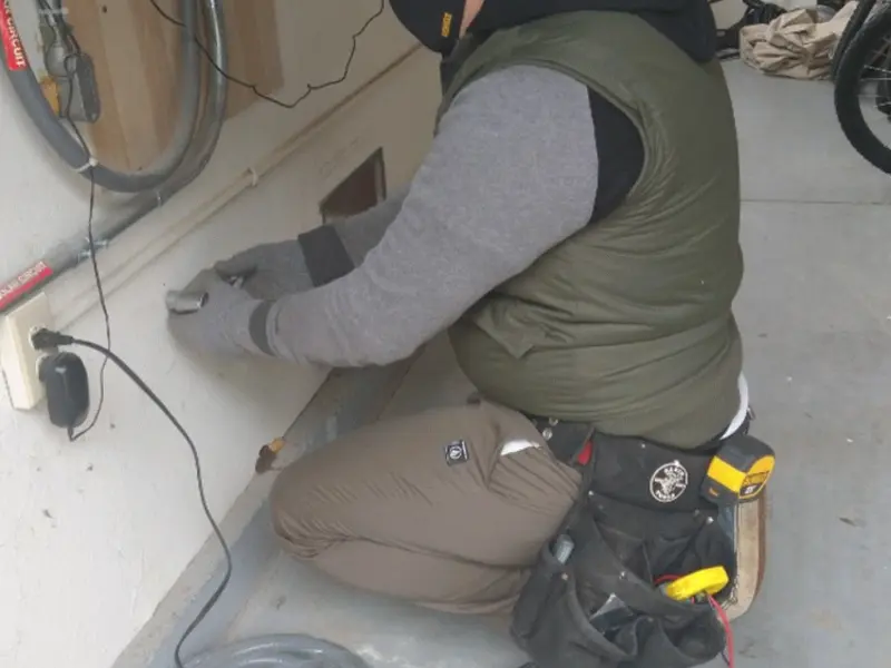 Electrician performing outlet wiring in a Ellington garage